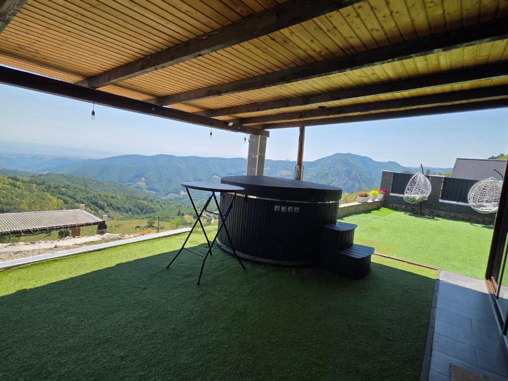 Ciubăr negru cu trepte, sub pergolă de lemn, cu panorama văii
