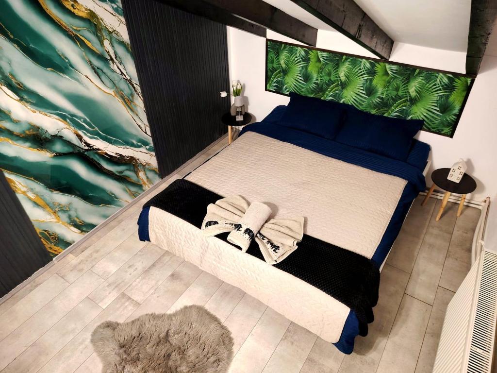Dormitor cu pat dublu, lenjerie bleumarin și blană decorativă pe parchet