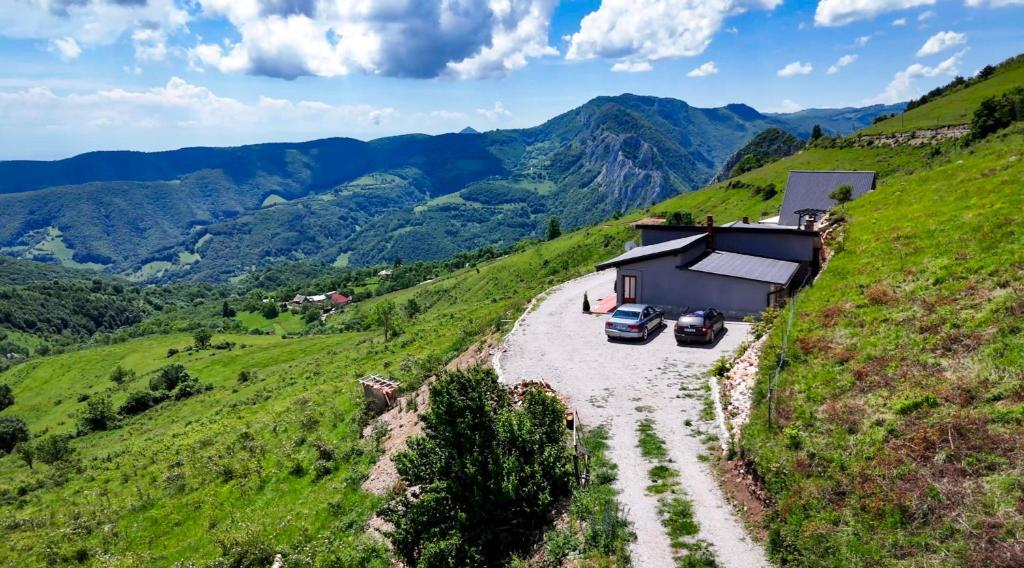 Casa pe creastă, cu drumul de acces și satul din vale