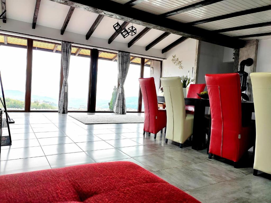 Living luminos, cu sobă metalică în colț și perete vitrat cu draperii